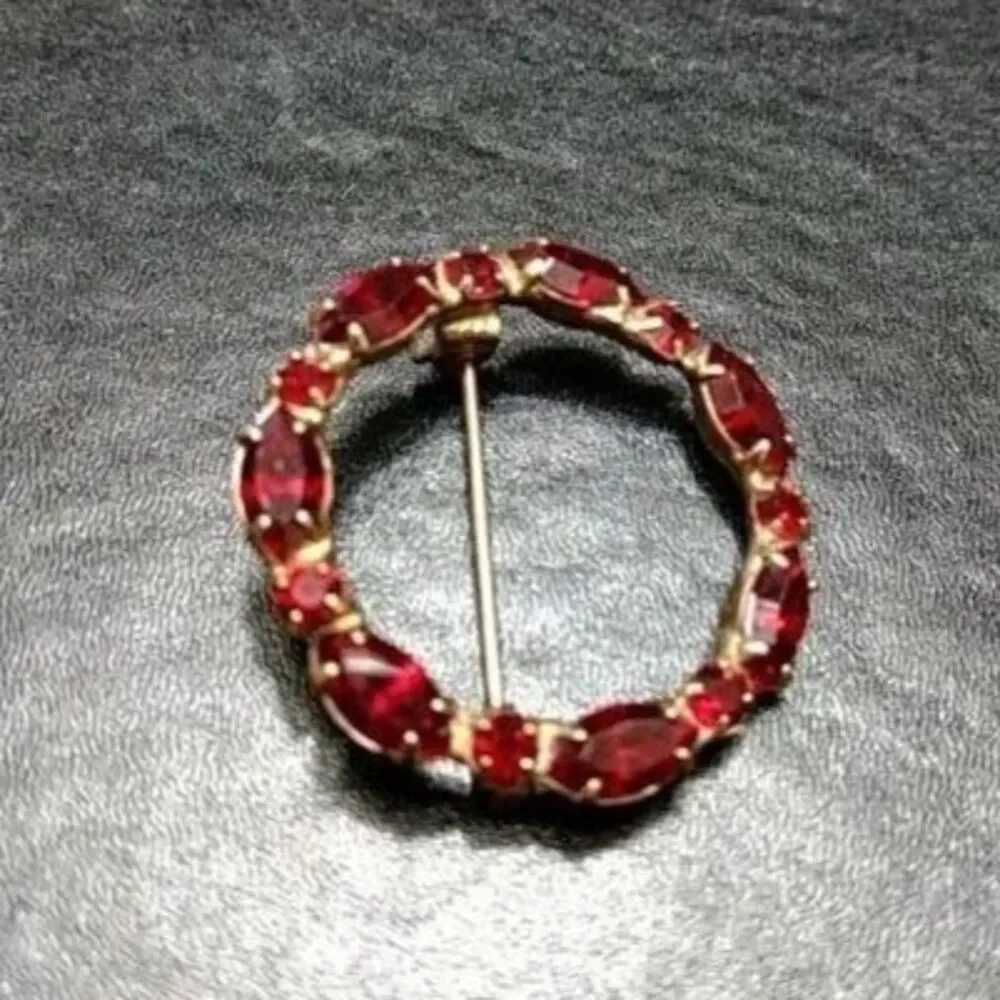 Vintage gold tone round pin w red rhinestones